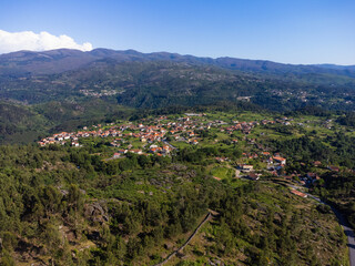 Obraz premium Beautiful and scenic aerial view of village of Gerês, Soajo, Portugal. Spring day. City, houses, mountains and waterfalls. Near Porto. Drone.