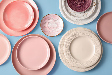 Clean plates, bowls and saucer on blue background. Top view