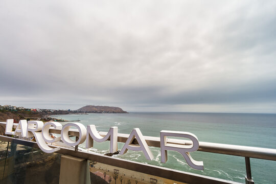 Lima, Peru - January 3, 2024: Larcomar shopping mall sign in Miraflroes district, with the sea and Chorrillos district in the background
