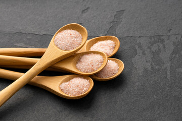 Fine salt crystals - Pink Himalayan salt in spoons.