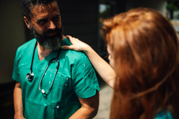 Medical professionals in discussion, comforting each other outside.
