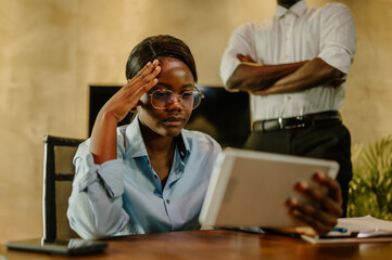 Black business woman solving a work problem and looking at the stats on a tablet