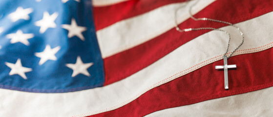 Christian cross necklace on American flag. For US Memorial Day, Veterans Day, USA memorial or...