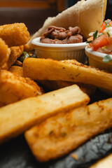 A closeup of a plate with french fries and a sandwich