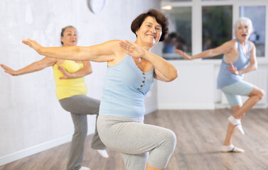 Obraz premium Three elderly women are learning sports Latin American dances in studio class. Joint pastime, active hobby