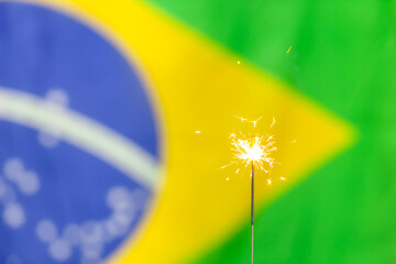 Uma velinha de estrelas acesa brilha com a bandeira brasileira no fundo para celebrar o Dia da Bandeira ou o dia da Proclamação da República Brasileira com um clima de festa.