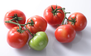 three tomatoes with water drops isolated on a white background