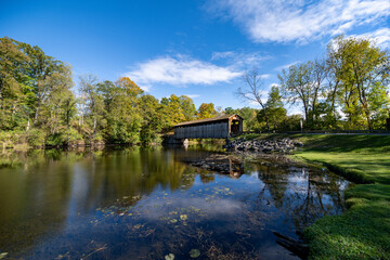 Fototapeta premium Fallasburg Covered Bridge over the Flat River in Fallasburg Village County Park in Lowell, MI