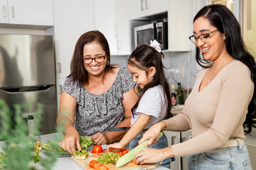 Family of three generations making a salad to the lunch. family time concept.