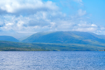 Mountain lake under blue sky with clouds