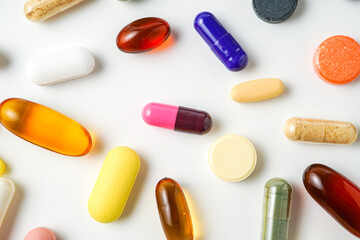 A lot of colorful medication pills capsules tablets softgel supplements, fish oil, vitamin, omega 3