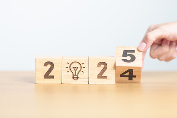 2024 year change to 2025 year block with lightbulb. Business Idea, Creative, Thinking, brainstorm,...