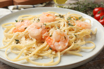 Delicious pasta with shrimps on wooden table, closeup