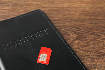 Obraz premium Passport and SIM card on wooden table, closeup