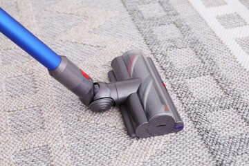 Cleaning rug with wireless handheld vacuum, closeup