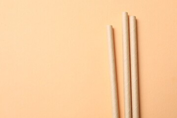 Bamboo drinking straws on beige background, top view. Space for text