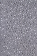 Water drops on gray background, top view