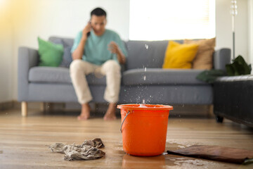 Young Asian Man Calling Complain Emergency Roof Leaking Damage Water Leak Or Flood From Ceiling
