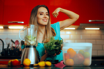 Strong Woman Making a Spinach Smoothie at Home for Breakfast. Happy powerful lady cooking healthy...