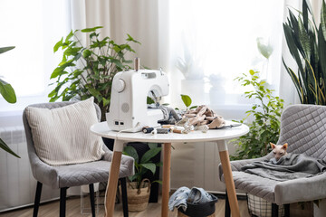 Workplace with a sewing machine. There are old blue jeans on the table.