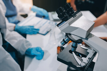 Scientist using microscope in laboratory. Close-up of a researcher's hands adjusting a modern microscope in a lab setting. Science concept