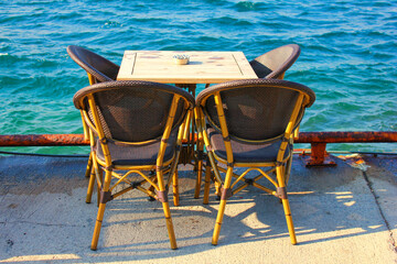 Fototapeta premium A table and four chairs by the beach in Istanbul