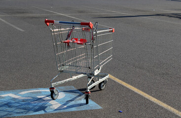 Metal shopping cart trolley abandoned in a handicap parking space