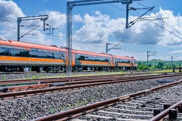 Saffron coloured Vande Bharat Express near Pune India. This is a tri-weekly train between Pune and...
