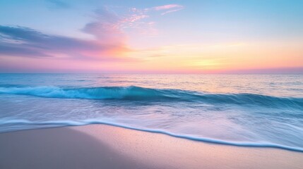 Naklejka premium The calm ocean gently meets the shore at sunrise, painting the sky with soft pastel colors