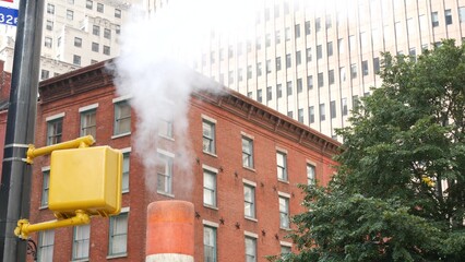 Steam vapor vented, New York City Water street, orange vapour tube stack. Hot smoke from pipe. Con...