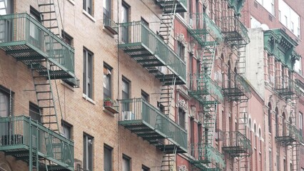 New York City classic building architecture, Manhattan, USA. Urban residential house exterior. Real estate property in United States. Typical red brick facade. Fire escape, emergency ladder exit.