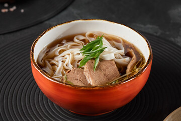 Vibrant Beef Pho Bo Soup in Rustic Bowl with Fresh Scallions