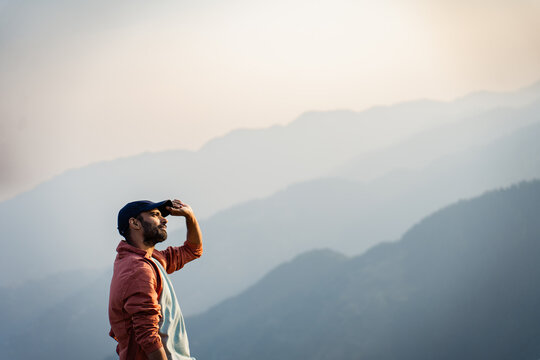 Man sitting at mountain top watching  dramatic sky at morning shot is taken Tirthan Valley,Shangarh Himachal Pradesh Indai.