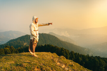 The man standing on a mountain top against a beautiful Sunset, Raghupur Fort, Jaroli Pass, Himachal...