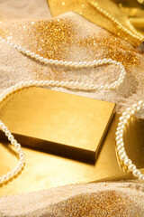 Creative photo with luxury theme, high angle shot on a sand-covered flat surface and gold dust....