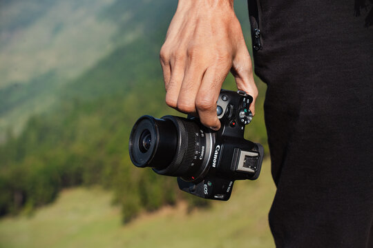 Himachal Pradesh, India- June 13, 2024: Canon eos R50 camera and photographer ready to take shutter on the nature of graden,Professional travel photography.