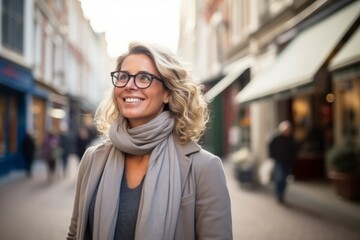 Obraz premium Portrait of a beautiful young woman with glasses and scarf in the city