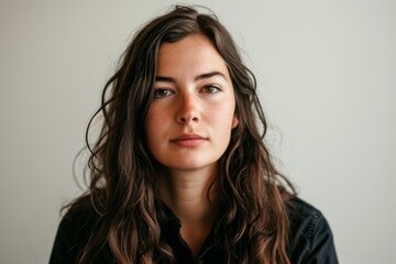Fototapeta premium Portrait of a beautiful young woman with long brown hair, studio shot