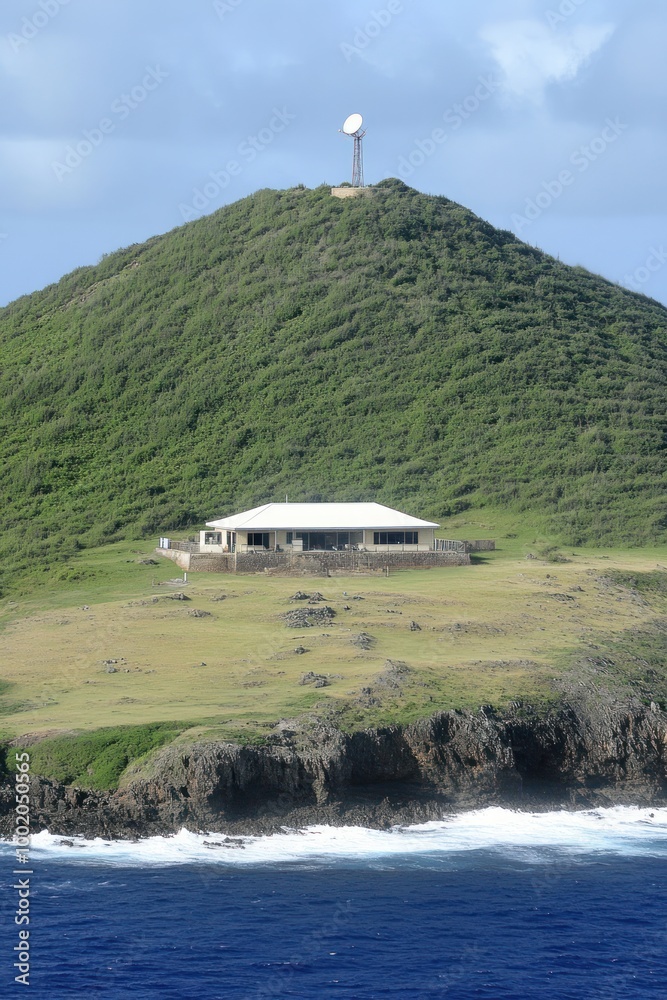 Poster A white house on a green grassy hill with a white tower on top. The hill is next to the ocean and has a rocky shore.