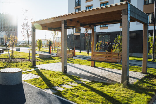 In the center of the park, there exists a beautifully constructed wooden pergola that enhances the outdoor space, providing a charming area for relaxation and leisure activities