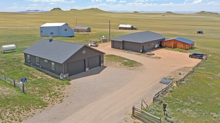 Obraz premium Aerial view of a rural property with multiple buildings and open landscape.