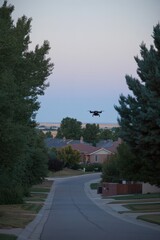 A drone flying over a suburban neighborhood at dusk, showcasing modern technology in leisure.