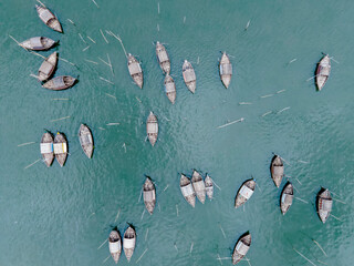 Aerial view of boatmen navigate their vessel across the Shitalakshya River, carrying passengers...
