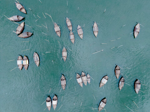 Aerial view of boatmen navigate their vessel across the Shitalakshya River, carrying passengers from Bandar Ghat in Narayanganj, Bangladesh.
