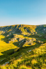 Romania Transalpina road with many serpentines crossing forest in  Carpathian mountains. Mountains forest trees with road in Parang mountains