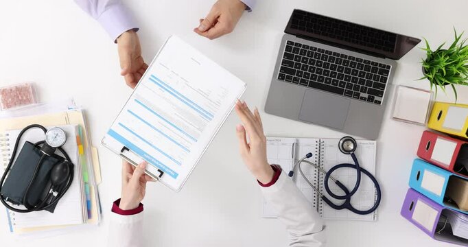 Doctor and patient review medical insurance form