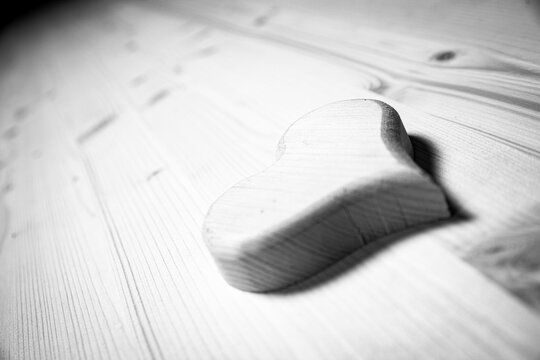 Black and white picture of Wooden heart lying on workshop bench