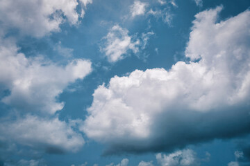 Obraz premium Quiet Skyline: Fluffy Clouds Sailing Through a Calm Blue Atmosphere.