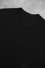 Close up of black long sleeve t-shirt  on grey background