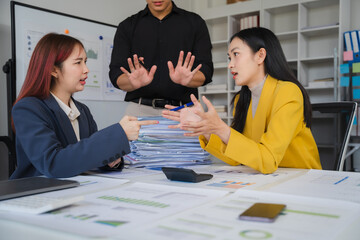 The Interruption: A tense moment in the office as a male manager tries to intervene between two female colleagues engaged in a heated discussion.